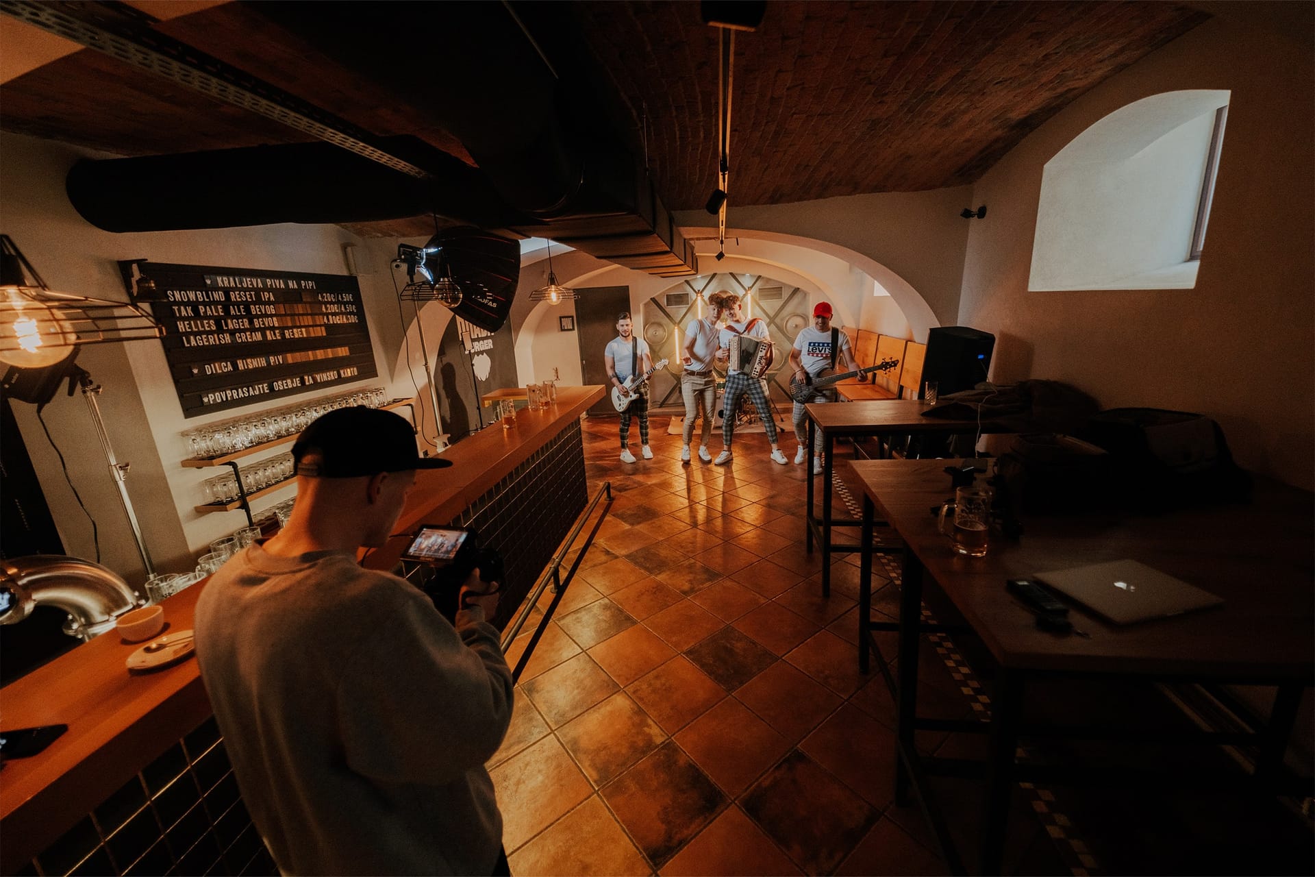 Snemanje glasbenega videa v obokani kleti z bendom in ekipo.