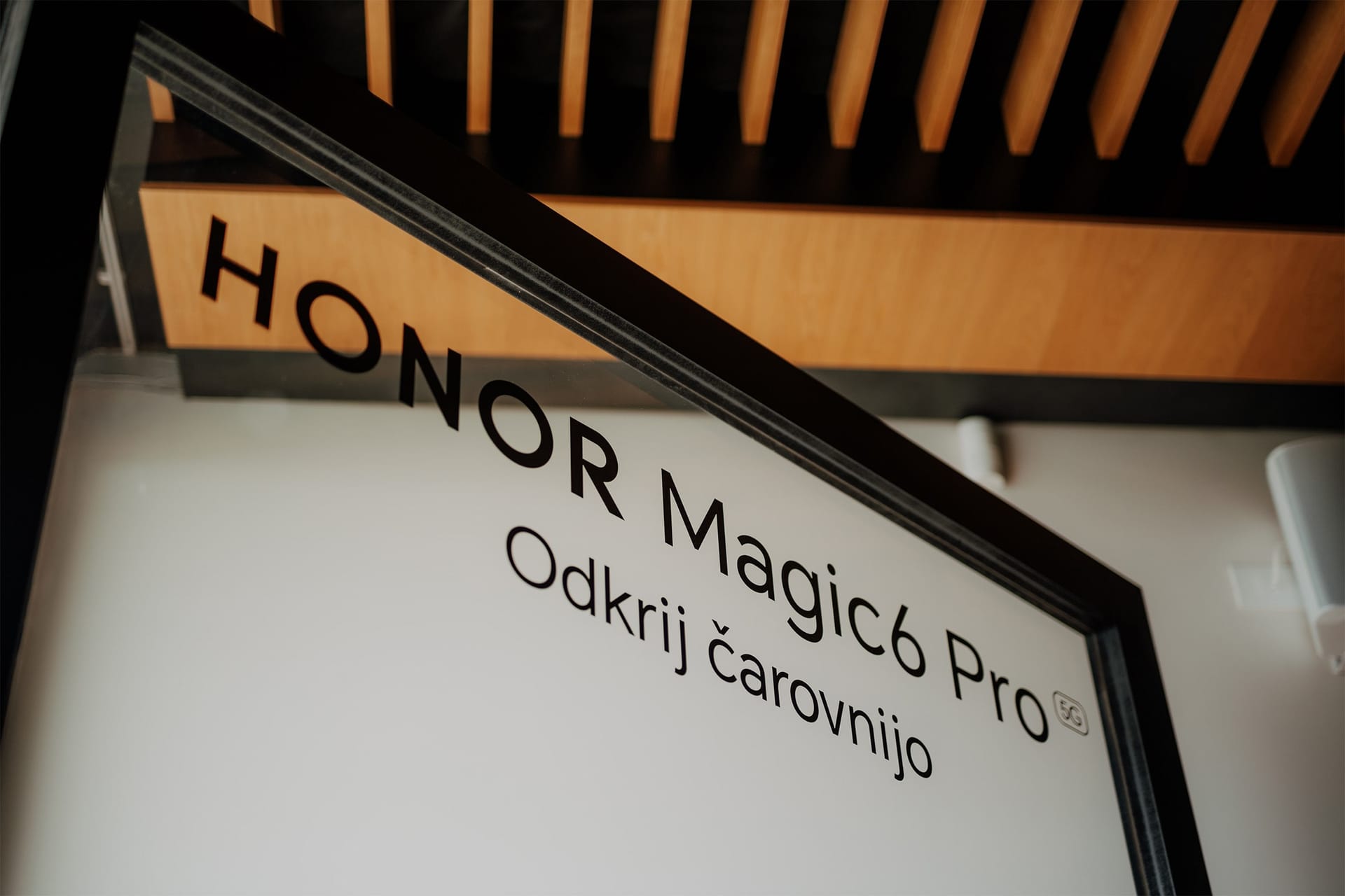 Reklamna tabla z napisom Honor Magic6 Pro in sloganom Odkrij čarovnijo.